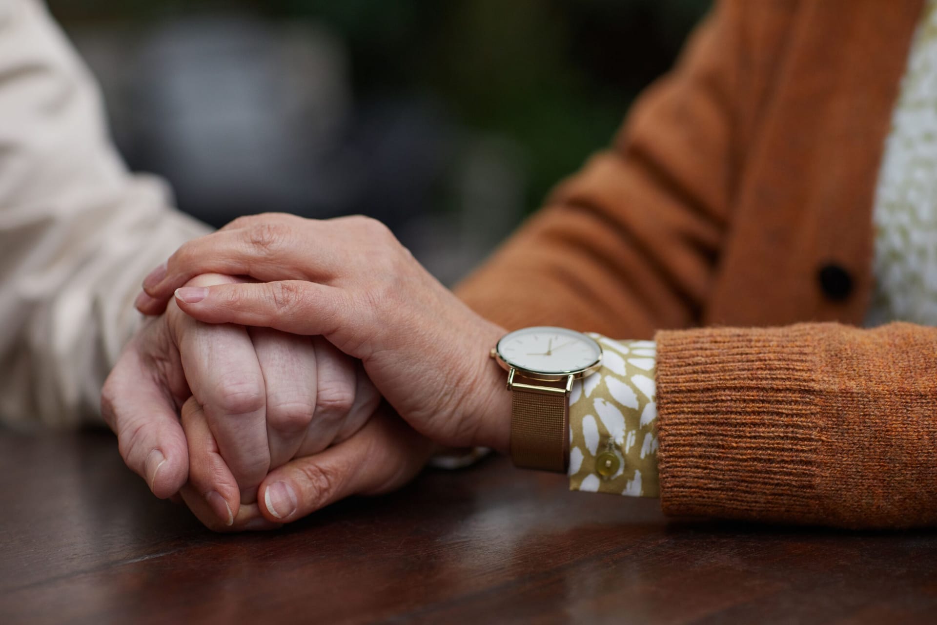 Caretaker holding hand of loved one